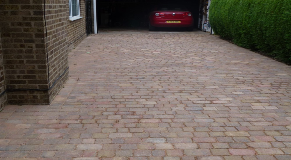 Tumbled block paved driveway leading to a garage