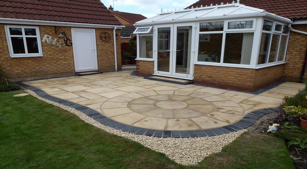Indian sandstone patio with circle feature and charcoal border